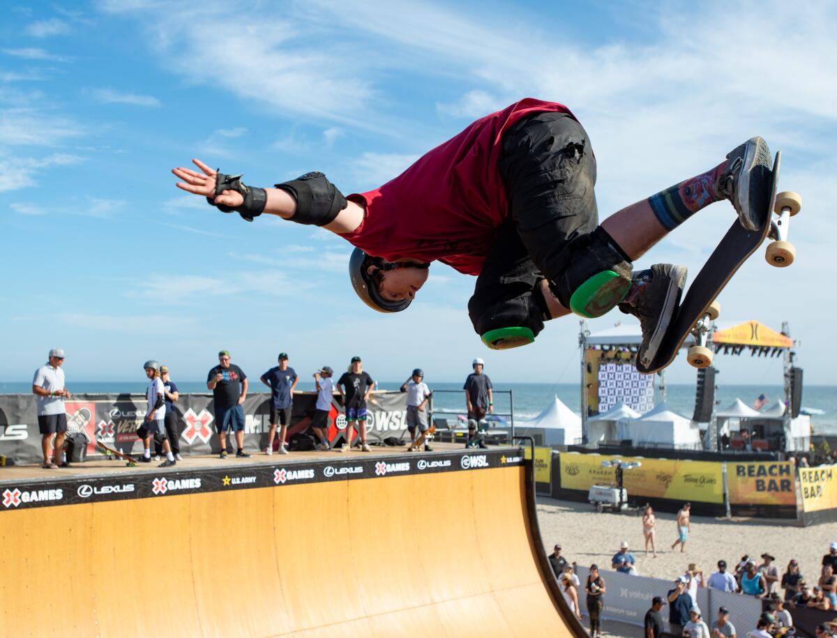 Skaters demonstrate their skills on a vert ramp built on the sand just south of Huntington Beach Pier.