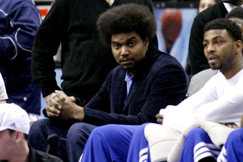 Sixers center Andrew Bynum sits on the bench as his team plays against the Golden State Warriors.