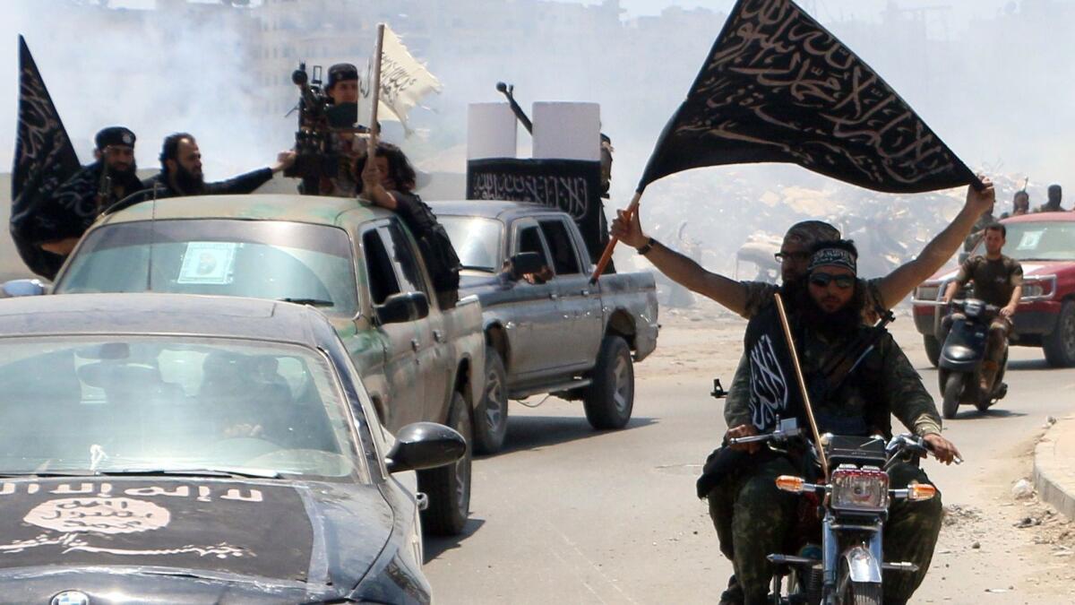 Fighters from Al-Qaeda's Syrian affiliate Al-Nusra Front drive in the northern Syrian city of Aleppo flying Islamist flags as they head to a frontline on May 26, 2015.
