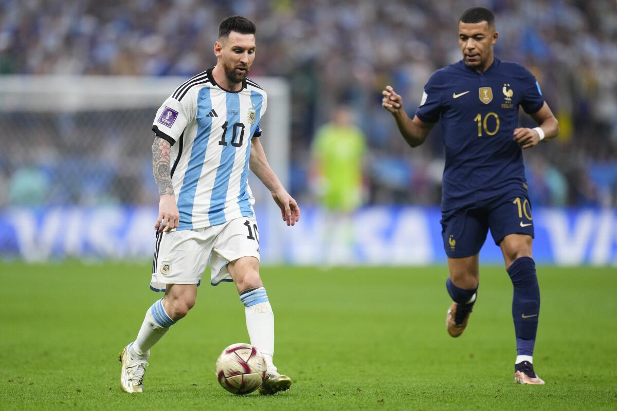 Lionel Messi, de la selección de Argentina, conduce el balón junto a Kylian Mbappé, de Francia, 