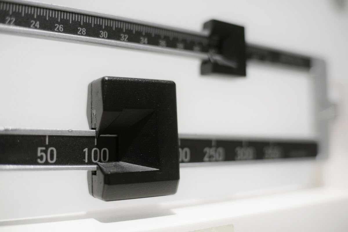 A close-up of a beam scale used for measuring a person's weight