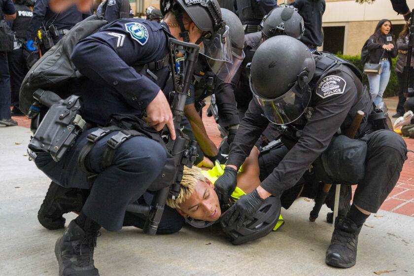 ARCHIVO - La policía tira al suelo a un manifestante pro-palestino para atarle las muñecas en la Universidad de California, Irvine, después de que la policía comenzara a desplazar a los manifestantes y un campamento fuera del patio, el 15 de mayo de 2024, en Irvine, California (Leonard Ortiz/The Orange County Register via AP, Archivo)