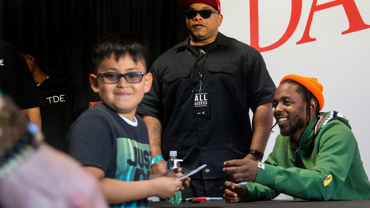Jonathan Virula, 7, of Bellflower gets an autograph from Kendrick Lamar at a store signing in Compton.