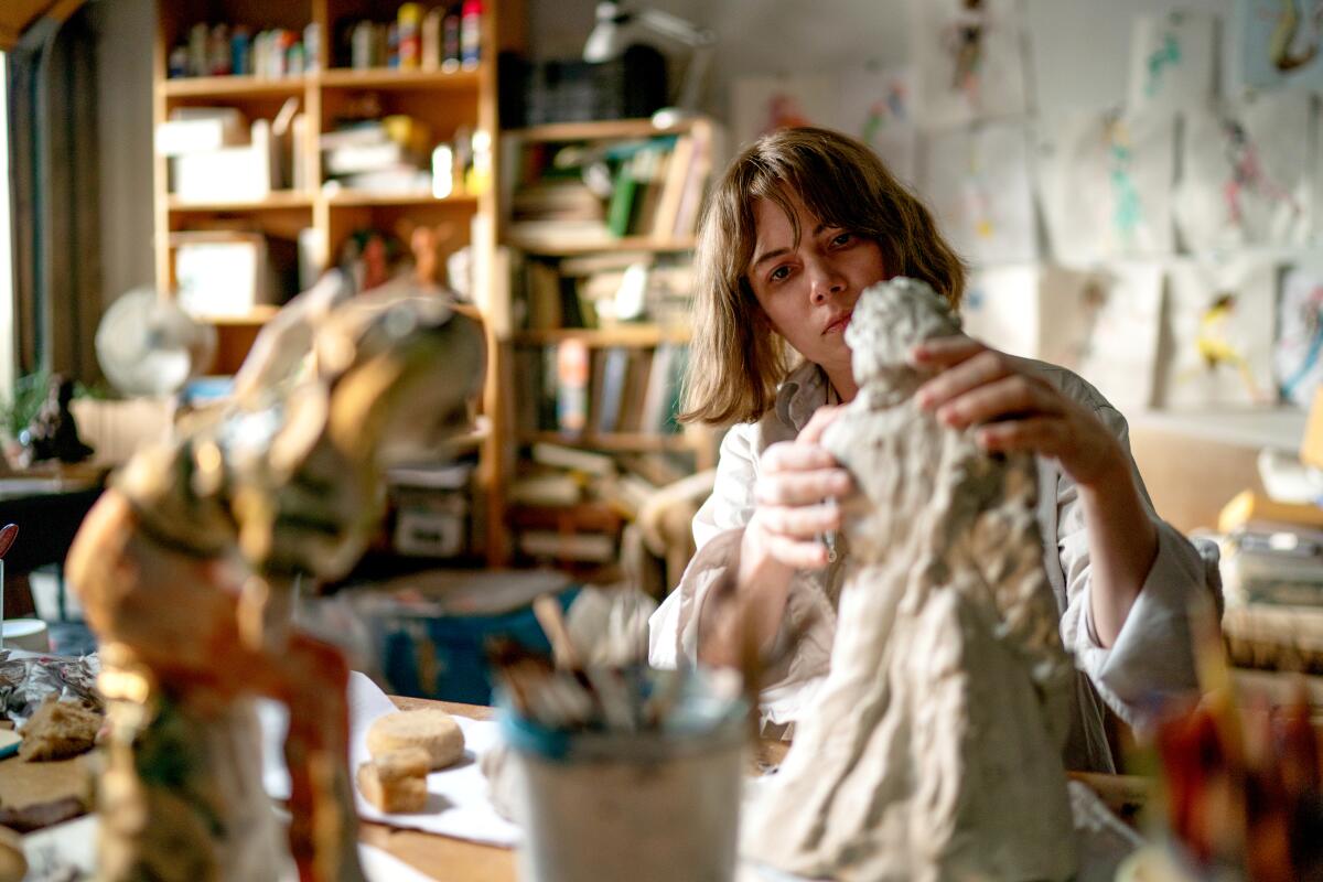 A woman sculpts in her studio.