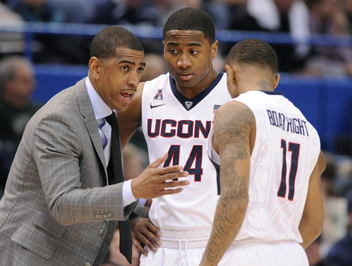 Connecticut Coach Kevin Ollie talks to his players Rodney Purvis (44) and Ryan Boatright (11) during a game March 12.