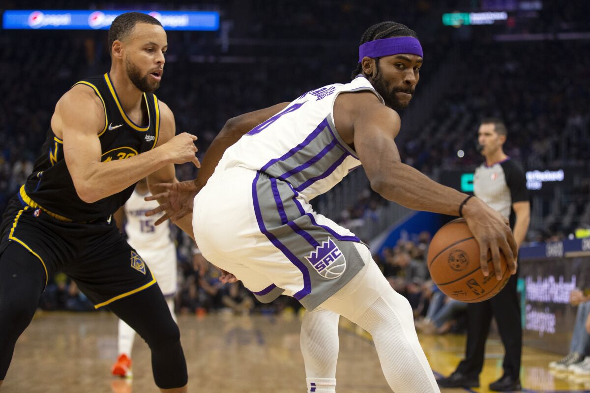 Sacramento Kings forward Maurice Harkless (8) looks to drive around Golden State Warriors guard Stephen Curry (30) during the first quarter of an NBA basketball game Thursday, Feb. 3, 2022, in San Francisco. (AP Photo/D. Ross Cameron)