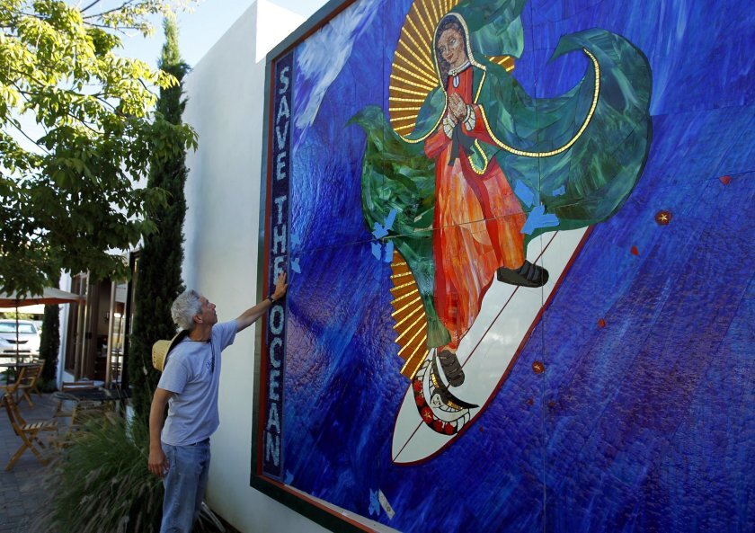 Artist Mark Patterson installed the Surfing Madonna on a wall next to Surfy Surfy surf shop on North Coast Highway in Leucadia on Monday, June 25, 2012. Patterson said the location was perfect fit for the piece that was originally under a train bridge in Encinitas.