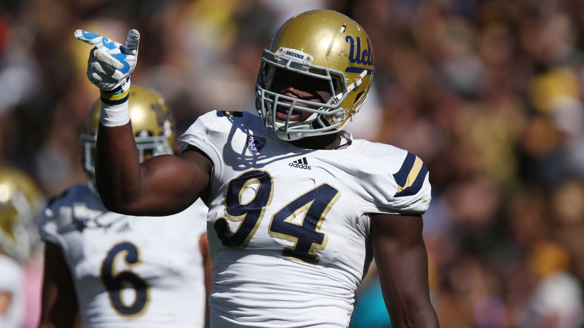 UCLA defensive lineman Owamagbe Odighizuwa gestures to teammates during the Bruins' win over Colorado on Oct. 25.