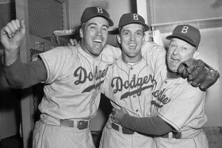 ARCHIVO - Foto del 5 de octubre de 1955, el pitcher de los Dodgers Carl Erskine, con su compañer Duke Snider y el mánager Charley Dressen tras ganar el juego 5 de la Serie Mundial ante Yankees. El martes 16 de abril del 2024, anuncian el fallecimiento de Erskine a los 97 años. (AP Foto)