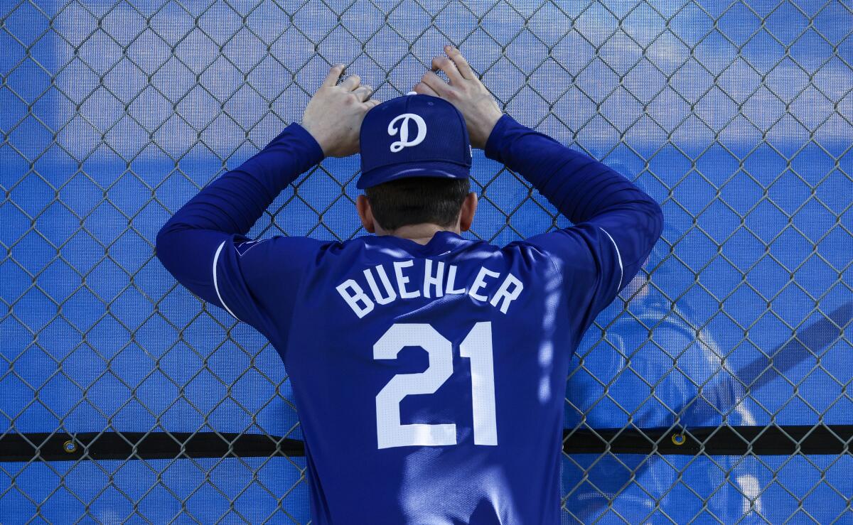 Los Angeles Dodgers' Walker Buehler looks on as teammate Yoshinobu Yamamoto throws a bullpen session.
