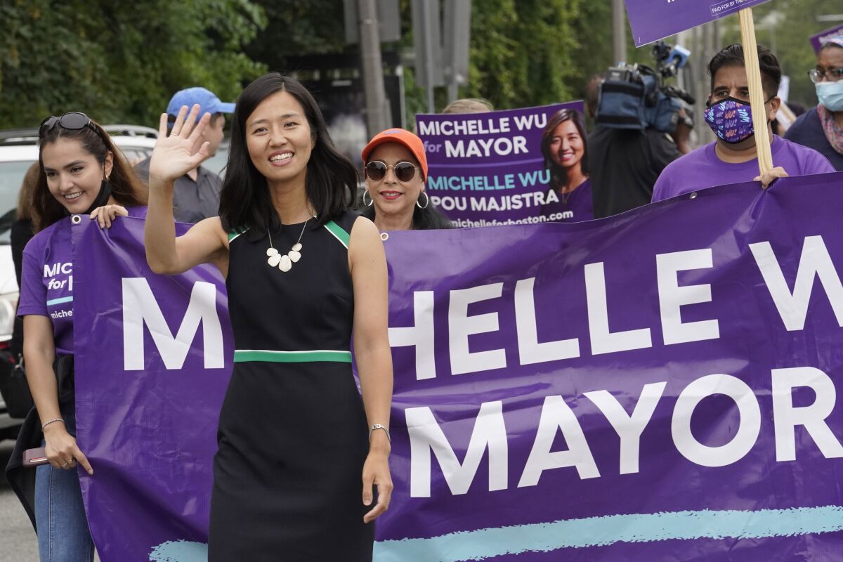 FILE— In this July 18, 2021 file photograph, Boston mayoral candidate Michelle Wu waves while walking in the Roxbury Unity Parade, in Boston's Roxbury neighborhood. With Boston's preliminary mayoral election just a month off, voters are on the verge of making a historic decision by narrowing the field of five major candidates, all of whom are people of color. Since it first started electing mayors nearly 200 years ago, Boston has only tapped white men to lead the city — a streak certain to end this year, a reflection in part of the city's changing demographics. (AP Photo/Steven Senne, File)