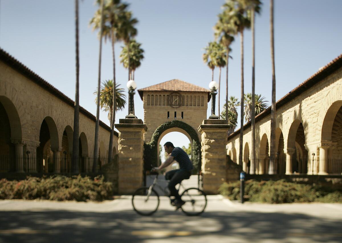 A bicyclist rides on the campus of Stanford University