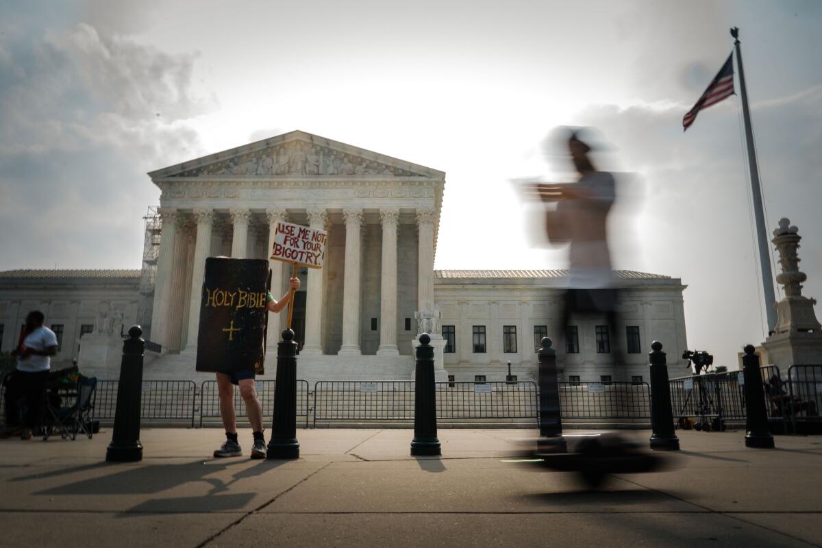 Man wears a Holy Bible sign outside the Supreme Court 