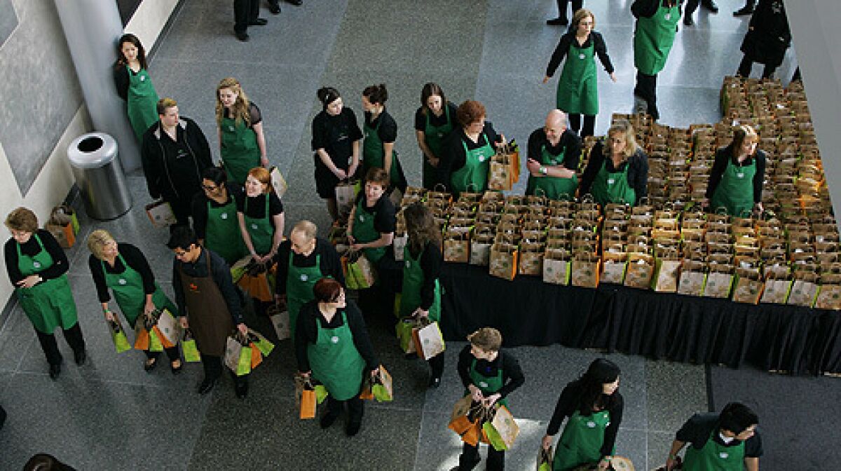 Starbucks Corp. employees wait to hand out gift bags Wednesday, March 19, 2008 at the end of Starbucks' annual shareholders meeting in Seattle.