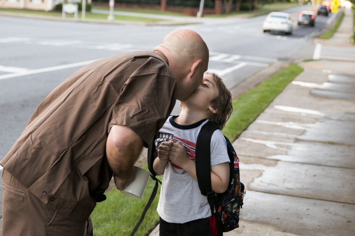 Jason Rochester gives Ashton a kiss as they wait for the school bus.