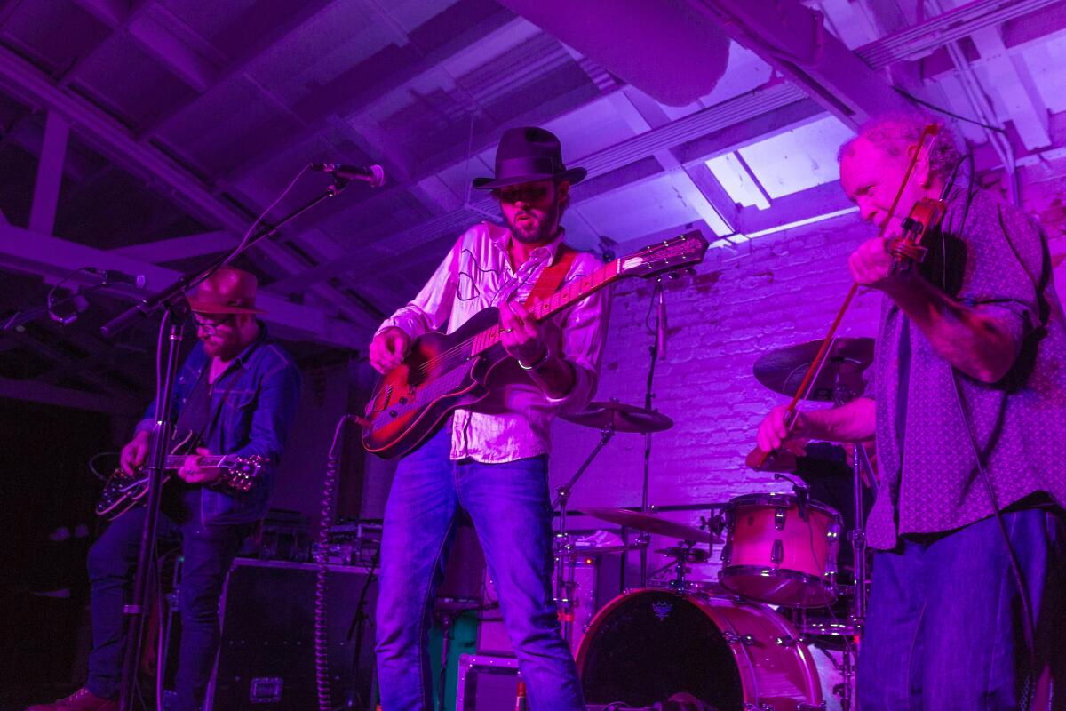 Three men onstage playing music