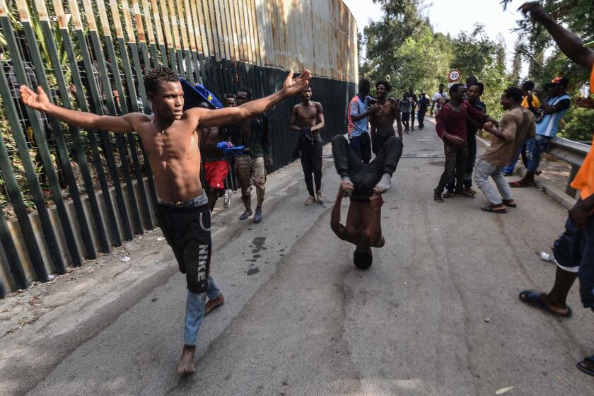 A group of men celebrate after forcing their way into the Spanish territory of Ceuta on August 22, 2018. - Over 100 migrants made their way into Ceuta after storming a barbed-wire border fence with Morocco and attacking police with caustic quicklime, a local official said. (Photo by Joaquin SANCHEZ / AFP) (Photo credit should read JOAQUIN SANCHEZ/AFP/Getty Images) ** OUTS - ELSENT, FPG, CM - OUTS * NM, PH, VA if sourced by CT, LA or MoD **