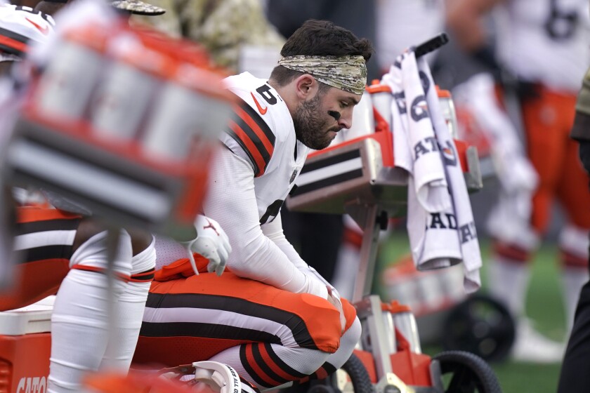 Cleveland Browns quarterback Baker Mayfield (6) sits on the bench after an apparent injury during the second half of an NFL football game against the New England Patriots, Sunday, Nov. 14, 2021, in Foxborough, Mass. The Patriots defeated the Browns 45-7. (AP Photo/Steven Senne)