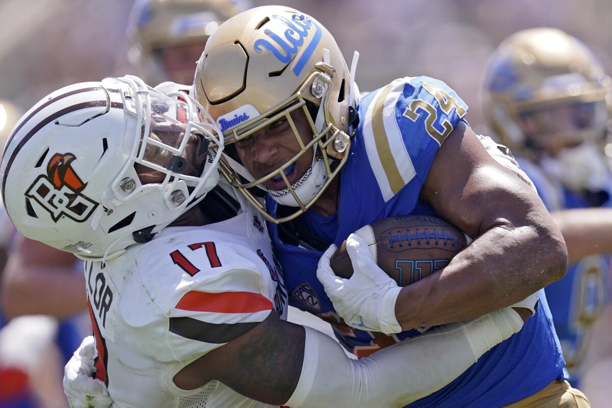 UCLA running back Braxton Todd, right, is tackled by Bowling Green linebacker DJ Taylor during the first half Saturday.