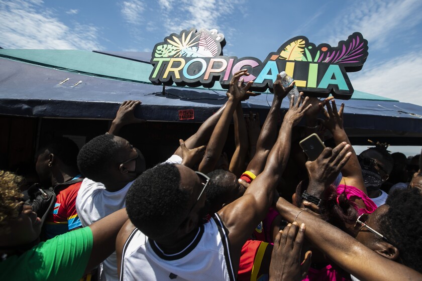 People rip a sign off a kiosk during a protest against the violent death of a Congolese immigrant earlier this week over an alleged pay dispute, in Rio de Janeiro, Brazil, Saturday, Feb. 5, 2022. The death of 24-year-old Moïse Mugenyi Kabagambe has sent shockwaves across Brazil after the assailants were caught on security camera footage attacking the young man, and over the course of 13 minutes holding him down and beating him with a rod — and continuing to do so even after he lost consciousness. (AP Photo/Bruna Prado)