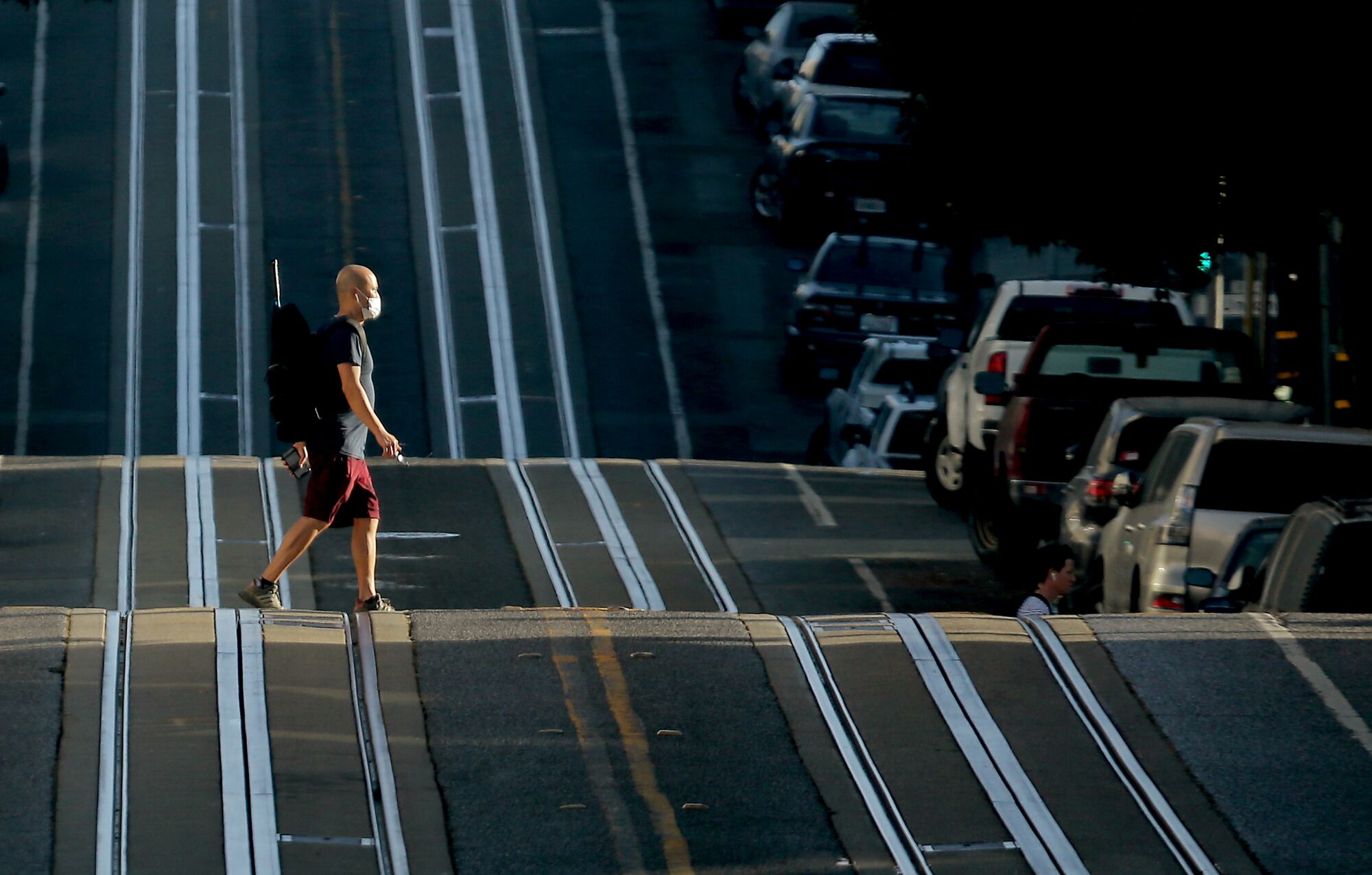 A pedestrian crosses cable car tracks in the North Beach neighborhood of San Francisco.