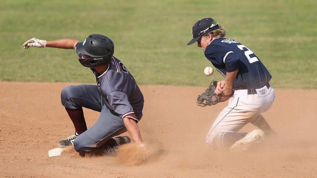 Laguna Beach High's Nolan Smith, shown sliding into second base as Newport Harbor's Mac Briggs (2) stops the ball on March 29, helped the Breakers beat Fountain Valley 2-1 in Tuesday's Ryan Lemmon Baseball Tournament game.