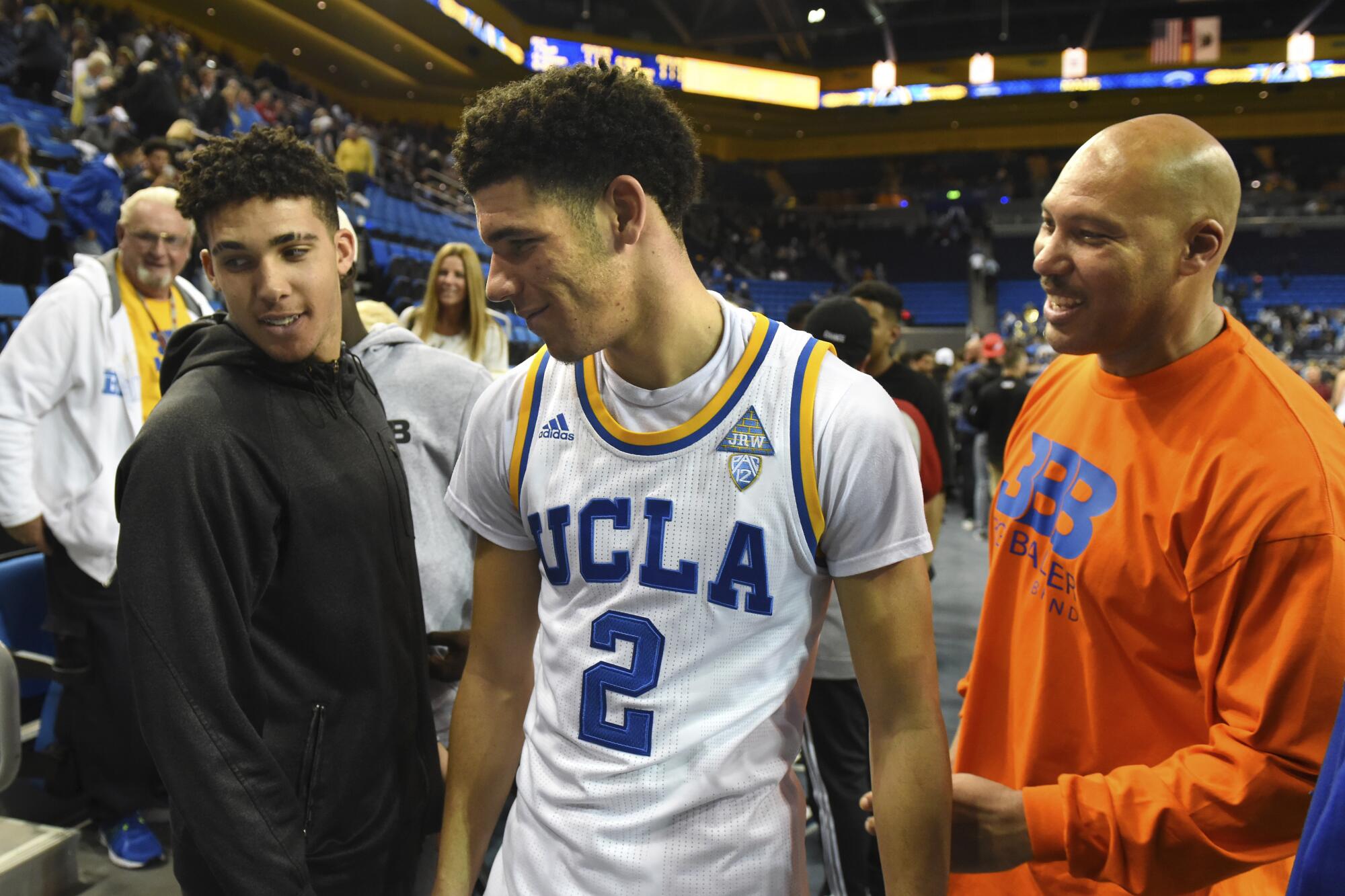 LaVar Ball watches as eldest son Lonzo greets middle brother LiAngelo after a UcLA game on Nov. 20, 2016.