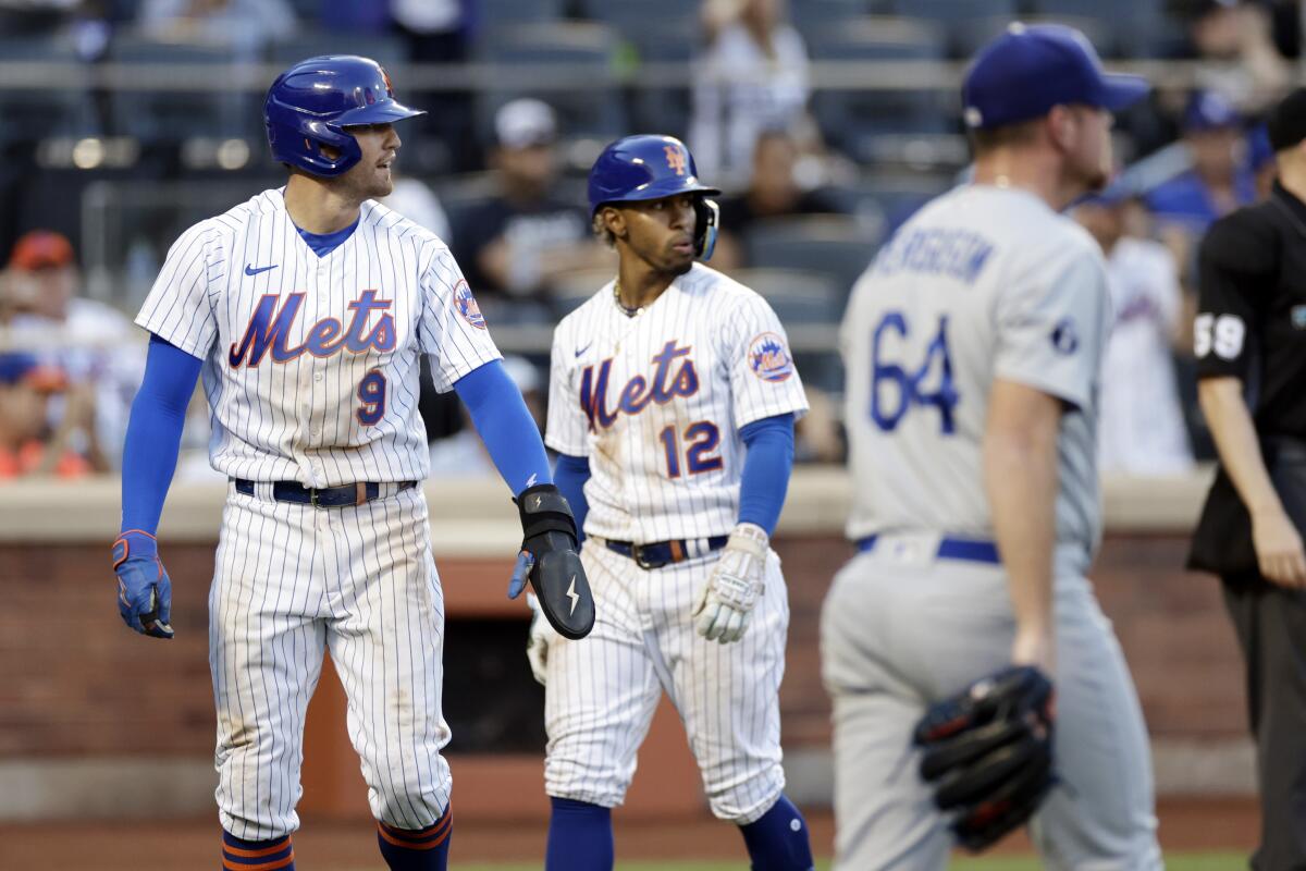 New York Mets' Brandon Nimmo (9) and Francisco Lindor (12) react near Dodgers pitcher Caleb Ferguson after Nimmo scored
