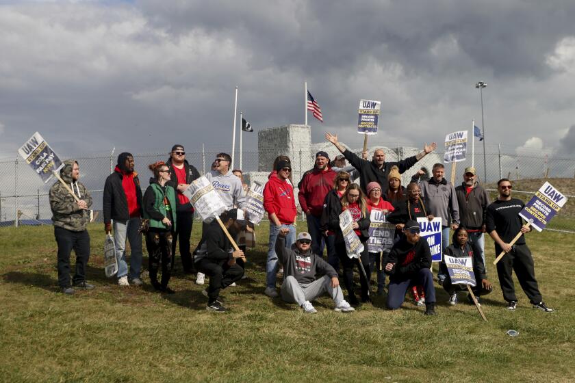 With arms outstretched, U.S. Sen. John Fetterman, D-Pa., poses for a photo with striking workers as he visits the United Auto Workers picket line at the Stellantis Toledo Assembly Complex on Friday, Oct. 20, 2023, in Toledo, Ohio. (Kurt Steiss/The Blade via AP)