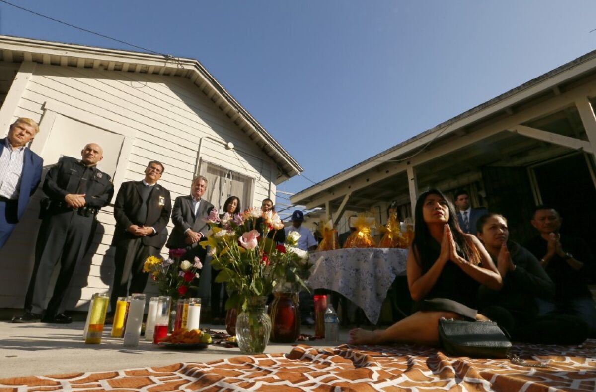 A memorial ceremony is held in the backyard of a Long Beach home where three people were killed on  Halloween night.