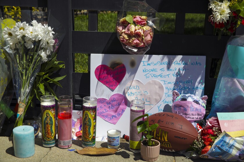 Heartfelt notes, flowers, candles and a football left by residents at a memorial