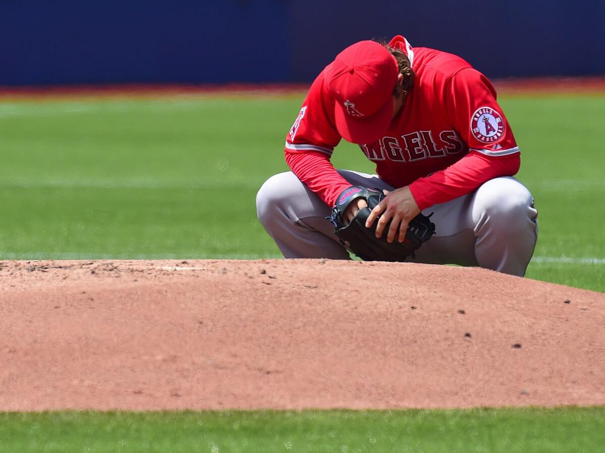 Angels starter C.J. Wilson crouches behind the mound during the first inning Monday against the Toronto Blue Jays.