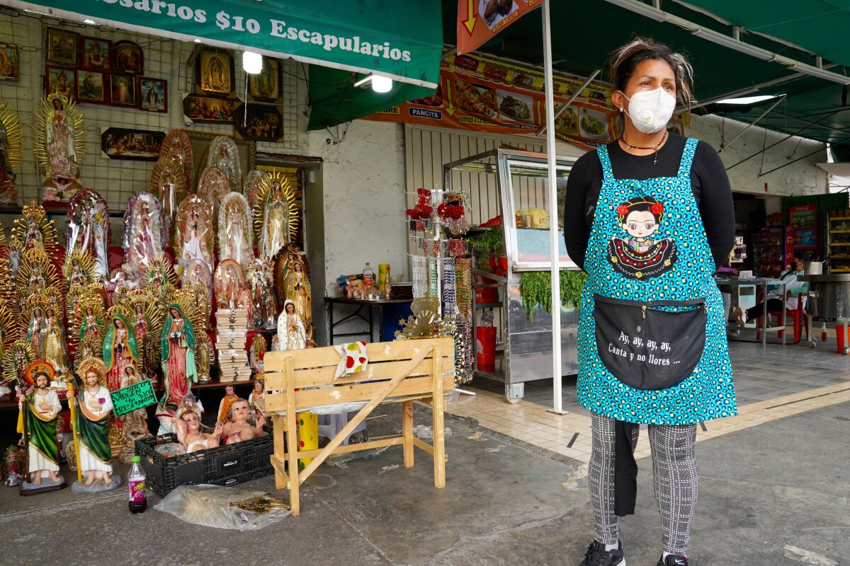 A shop owner stands outside one of the few stores that were open selling religious items and figures near the basilica.