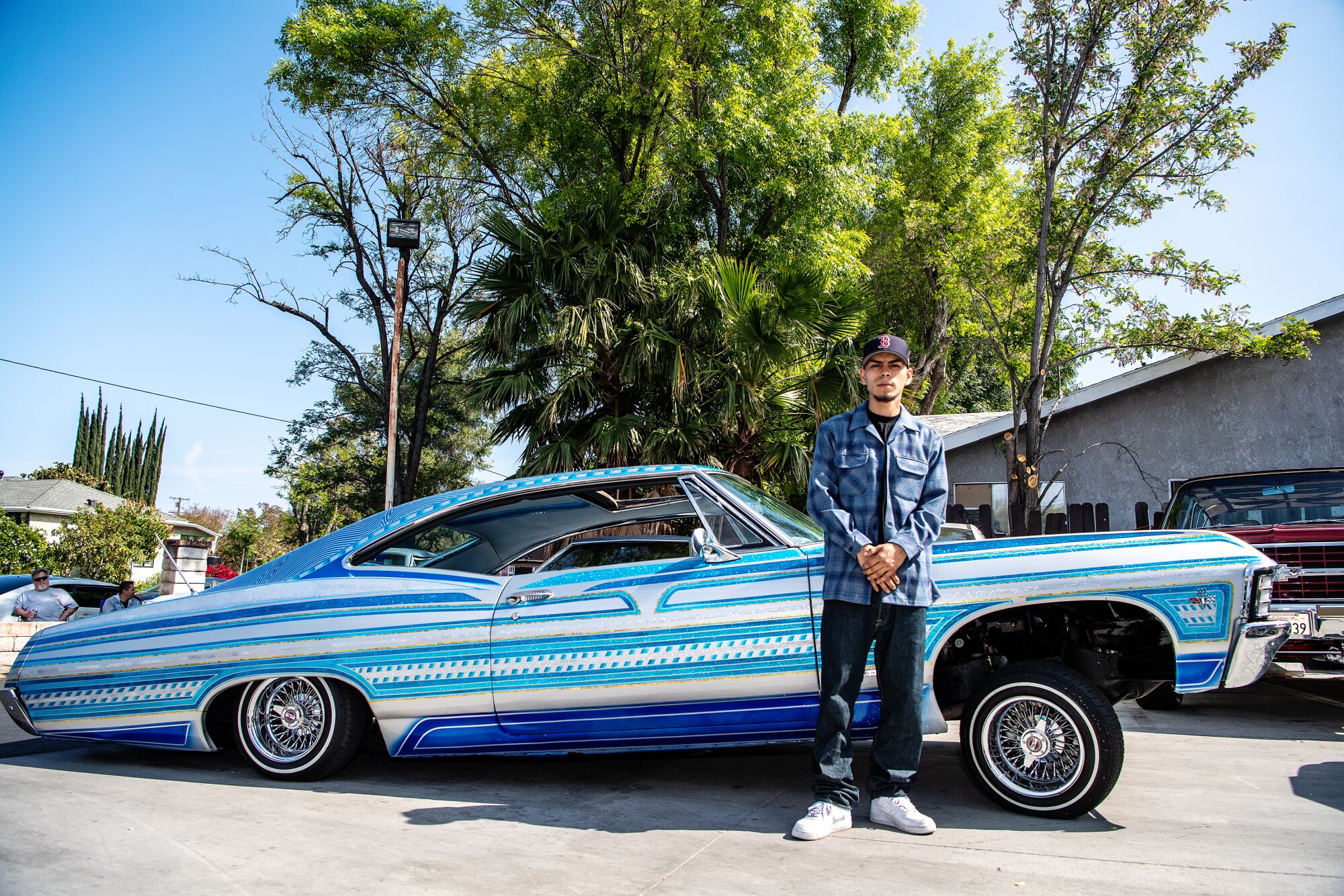Victor Martinez poses in front of a 1967 Chevrolet Impala.
