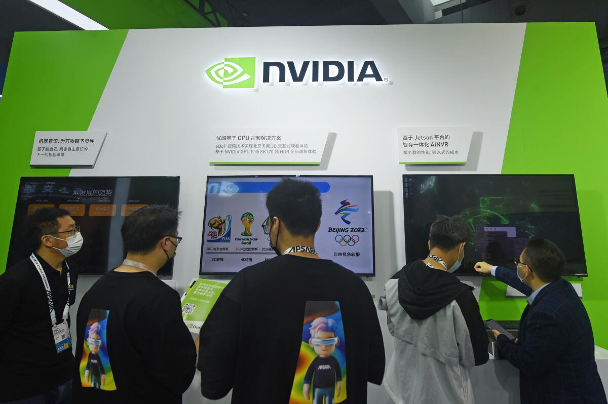Visitors stop by the booth of Nvidia at the Apsara Conference, an annual cloud service technology forum hosted by Alibaba Group, in Hangzhou in eastern China's Zhejiang province Tuesday, Oct. 19, 2021. The Chinese government on Thursday, Sept. 1, 2022, called on Washington to repeal its technology export curbs after chip designer Nvidia Corp. said a new product might be delayed and some work might be moved out of China. (Chinatopix Via AP)