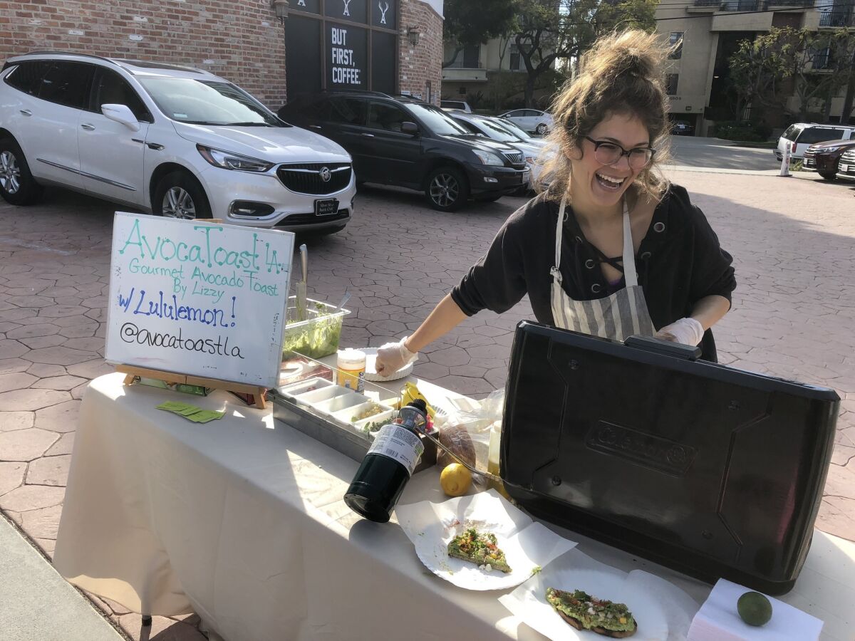 Lizzy Cooper serves avocado toast with corn and cotija cheese at Lululemon Athletica in Brentwood as part of its marathon cheer station.