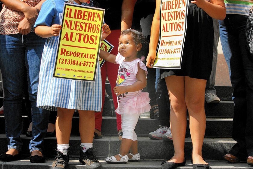 Yaretzie Vasquez, center, of Baldwin Park joins her mother, sister and supporters and members of the Free Our Cars Coaltion at a 2013 rally outside the County Hall of Administration calling for a change in towing and impound practices in Los Angeles.