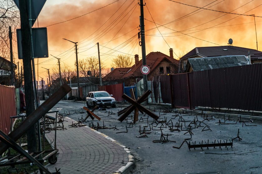Neighborhood near front line with barriers on the street and smoke in the air