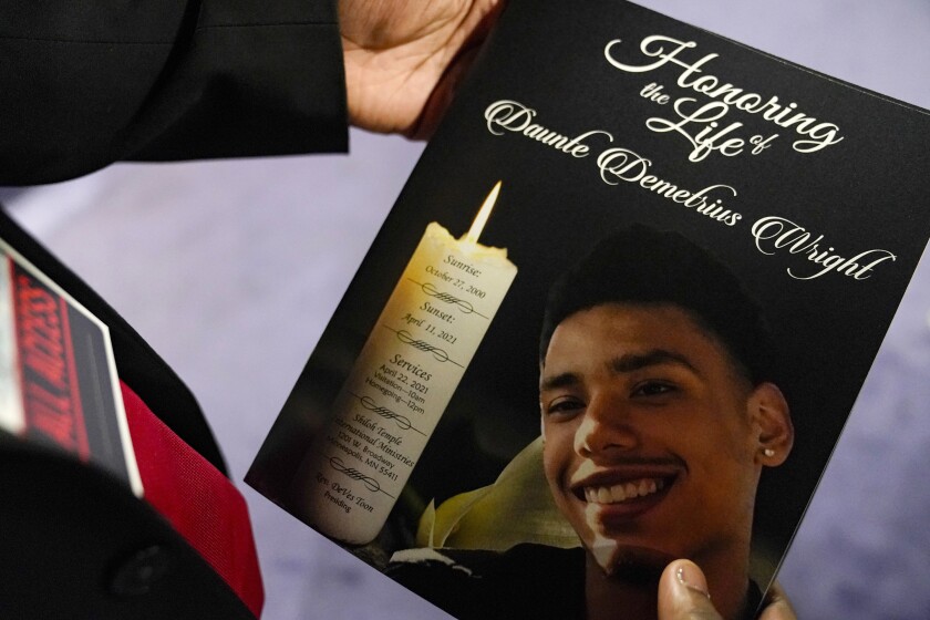 A mourner holds a program for the funeral services of Daunte Wright