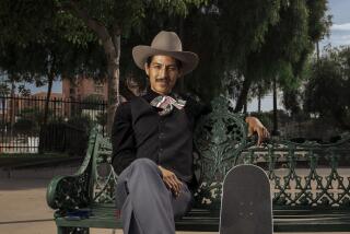 Steve Corona, 31, wears ranchero style clothing while sitting with his skateboard at Mariachi Plaza in Boyle Heights on Friday, September 23, 2023.