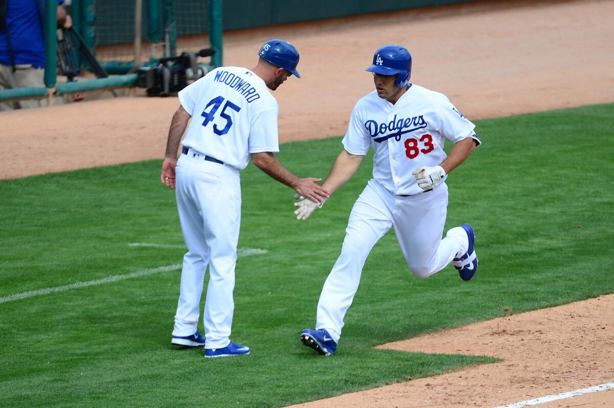 Dodgers third base coach Chris Woodward congratulates Rob Segedin after his two-run home run against the Diamondbacks during a spring training game on March 5.