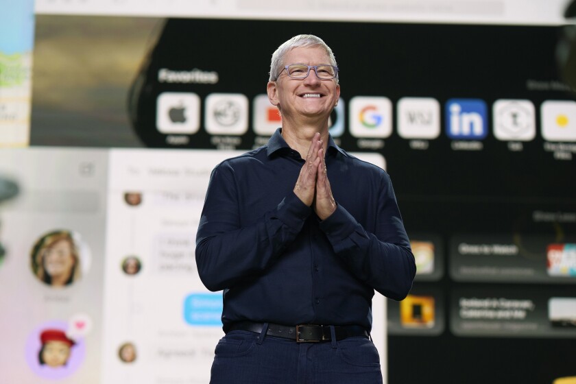 Apple Chief Executive Tim Cook stands on a stage.