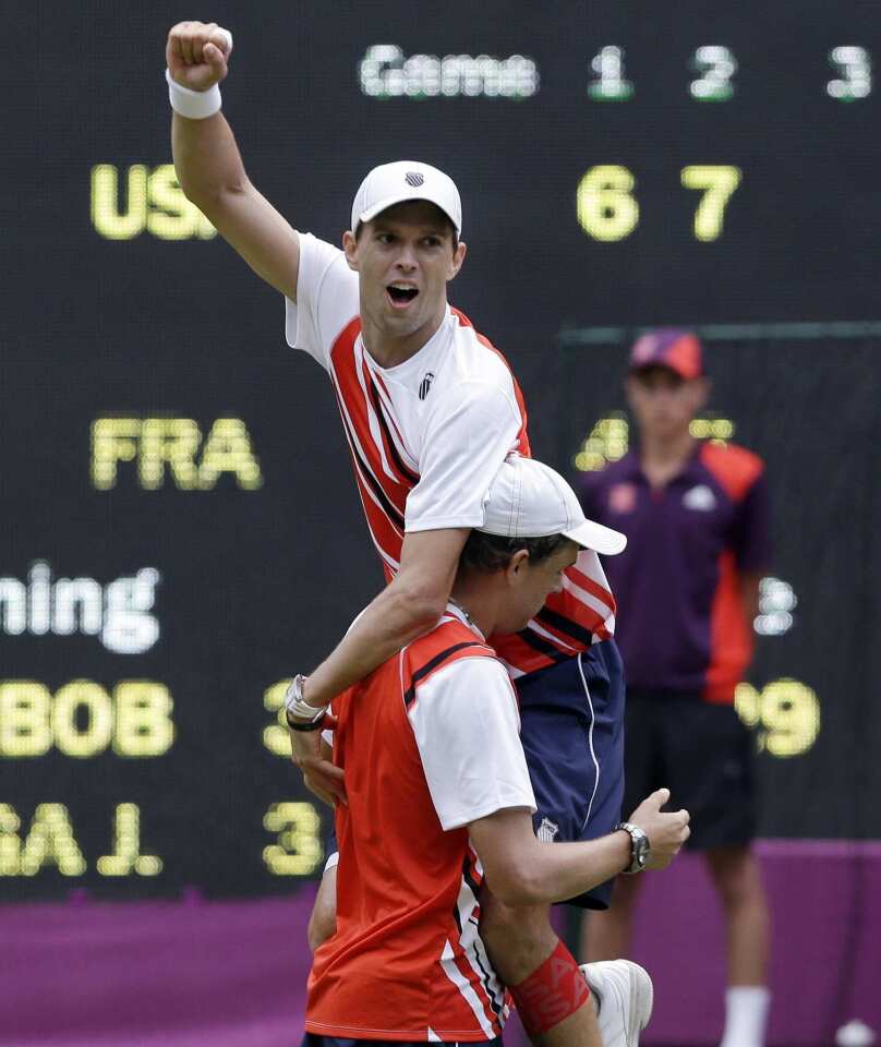 United States' Mike Bryan, top, and his twin brother Bob celebrate after defeating Jo-Wilfried Tsonga and Michael Llodra of France in the men's tennis doubles gold medal match.