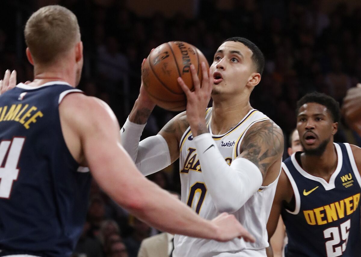 Lakers forward Kyle Kuzma tries to shoot over Denver Nuggets center Mason Plumlee during the second quarter of the Lakers' 128-104 loss Sunday at Staples Center.