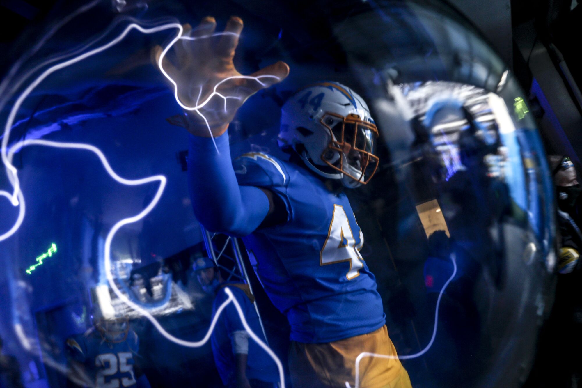 Los Angeles Chargers outside linebacker Kyzir White touches a lightning orb.