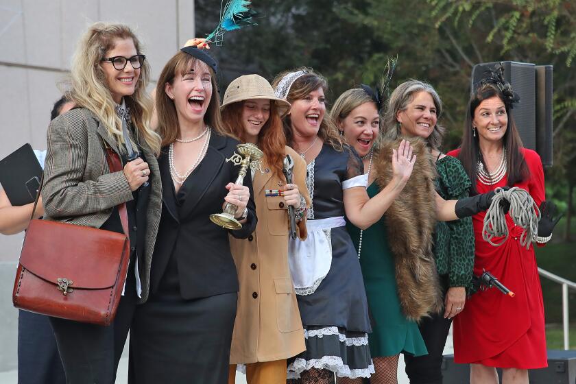 A group of ladies who came as a group gather for first place picture during the Clue Character Costume Contest.