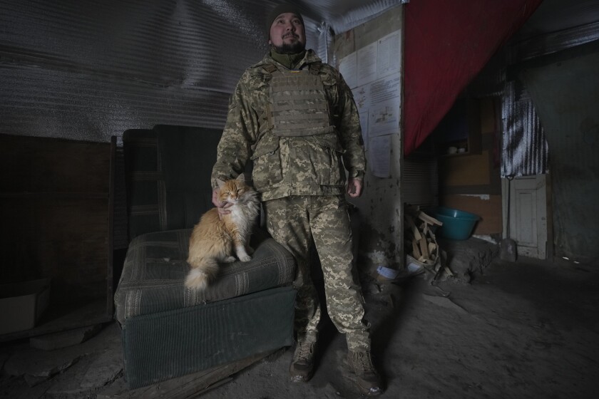Un solado ucraniano juega con el gato Vasily en un puesto de avanzada en la zona de Luhansk, 