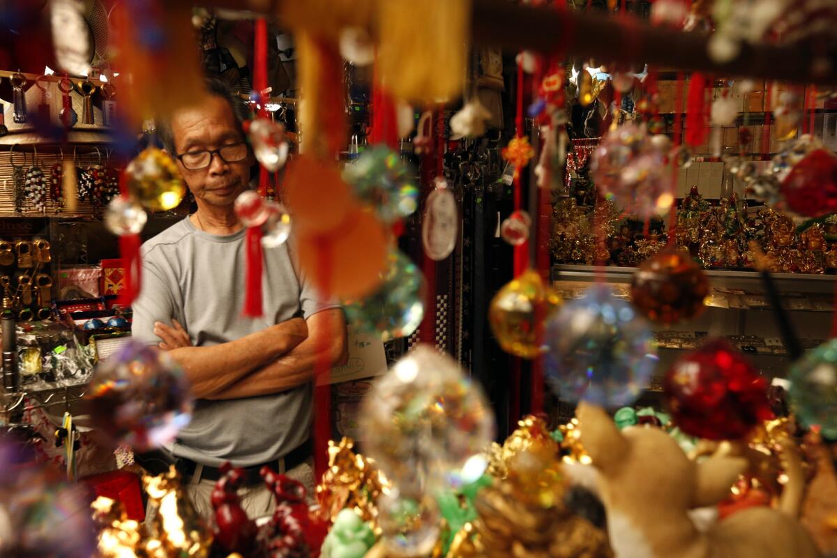 Hong Ngyuen, 70, waits for customers in his section of the swap meets inside Dynasty Plaza in Chinatown.