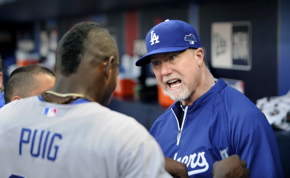 Dodgers batting coach Mark McGwire talks with outfielder Yasiel Puig during the 2013 playoffs.
