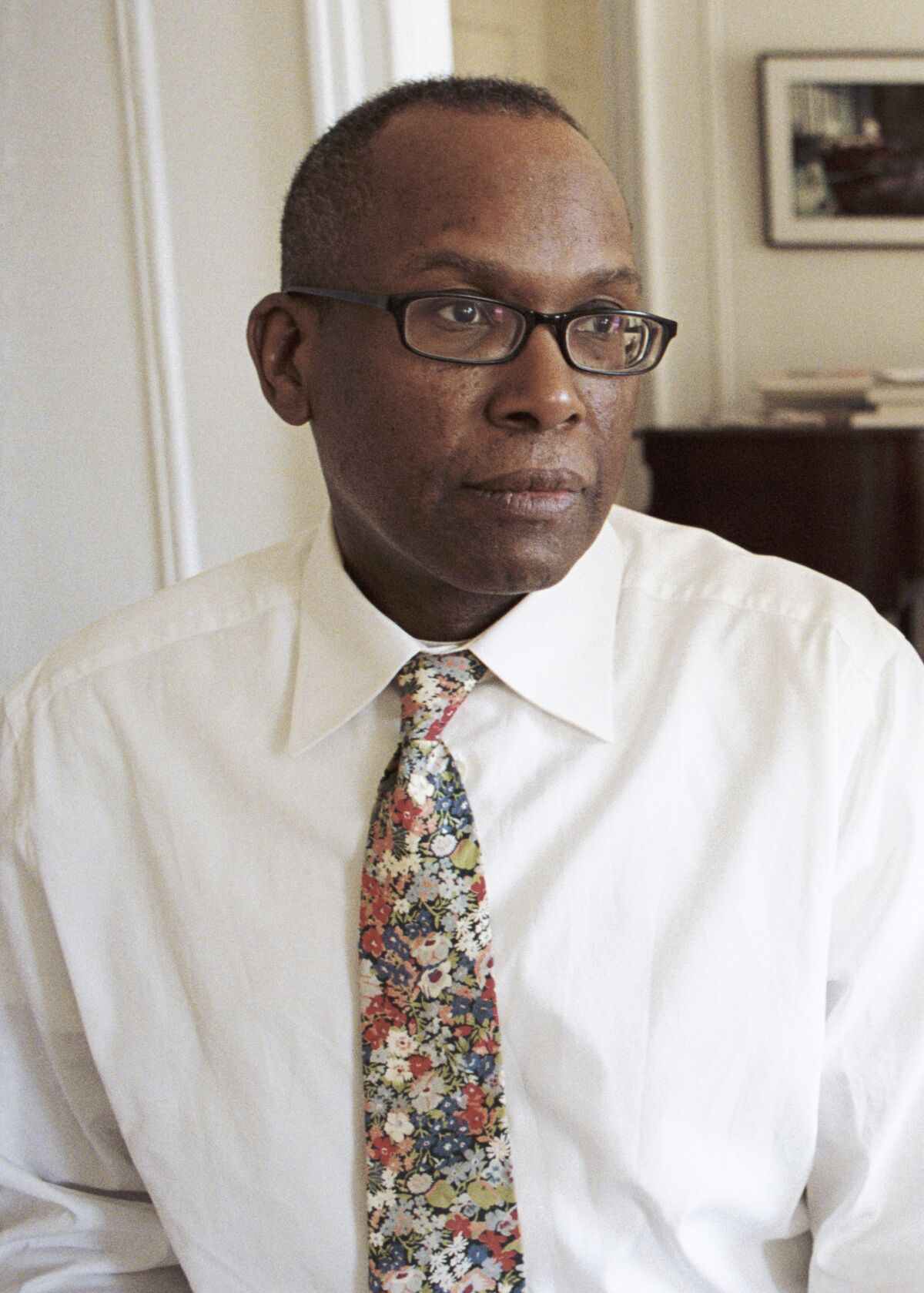 A Black man in a white button-down and a floral tie